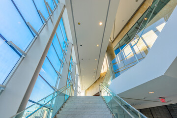 Fototapeta premium Window and blue sky. Abstract fragment of the architecture of modern lobby, hallway of the luxury hotel, shopping mall, business center in Vancouver, Canada. Interior design.