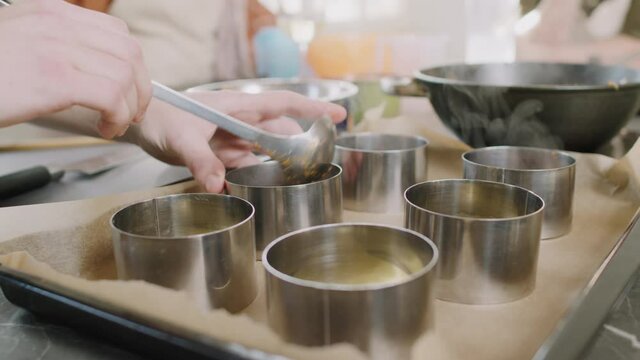 Close up of unrecognizable chef using stainless ring molds for forming lasagna showing master class at cooking class