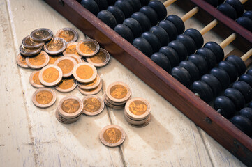 Golden coins with  abacus on table.