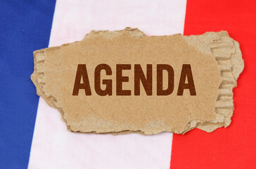 Against the background of the French flag lies cardboard with the inscription - AGENDA