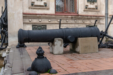 An old ship's cannon. Weapons on a pedestal at a historic building in Sevastopol.