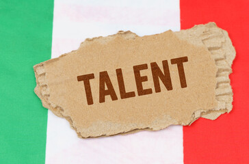 Against the background of the flag of Italy lies cardboard with the inscription - talent