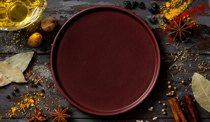 Various spices on an old wooden dark background top view. Free space for text. Cooking. Spices background. Turmeric, paprika, anise, cinnamon, curry, nutmeg, bay leaf and other spices.