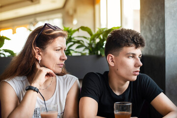 Mom talks to her teenage son in a cafe, the guy rolls his eyes, apparently does not want to listen...