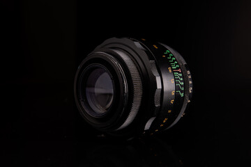 The lens on the black background. Optics, camera tool, old, retro, focus, scale