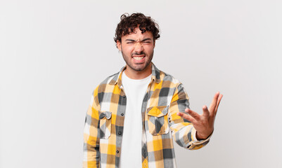 hispanic handsome man looking angry, annoyed and frustrated screaming wtf or what’s wrong with you