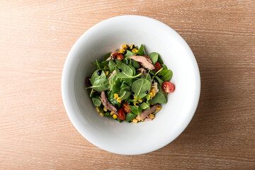Tuna Salad in white bowl on wooden table