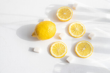 Sliced lemon on a white background . Lemon layout. Sliced fruit. Yellow color. White background. Light and shadow. Citrus. Copy space