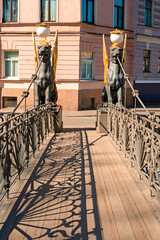 Naklejka premium The architectural historical monument of the Hanging Bank Bridge with lions on the Griboyedov Canal in St. Petersburg on a sunny clear day.