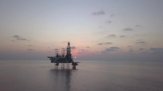 Aerial view of the jack up rig shot during sunset time. Fly around the jack up rig with a drone.
