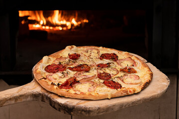 Brazilian style pizza entering the wood oven