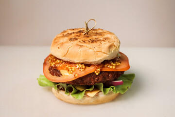 Delicious large burger on the white background, fast food concept. Burger consists of two buns,...