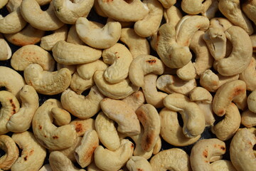 Freshly roasted cashews with salt background pattern closeup