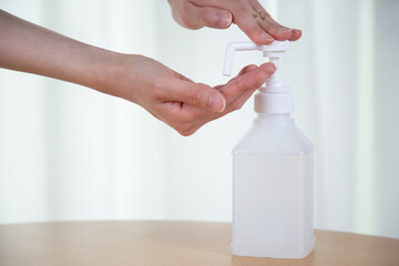 消毒用アルコールを手に吹きかける様子