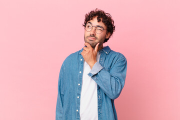 hispanic handsome man thinking, feeling doubtful and confused, with different options, wondering...