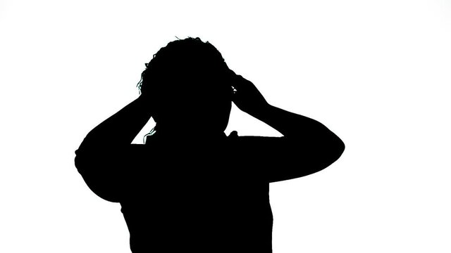 Silhouette of a woman holding her head in an ache tin.