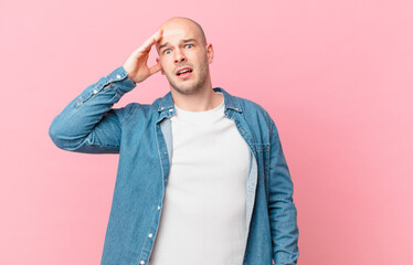 bald man looking happy, astonished and surprised, smiling and realizing amazing and incredible good...