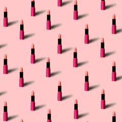 Red lipstick on pink colored background in pop art style. Minimal makeup cosmetic pattern.