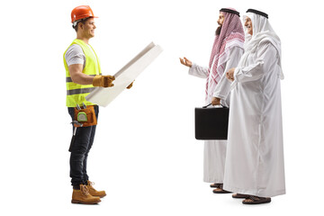 Full length profile shot of a construction worker holding a blueprint and talking to arab businessmen