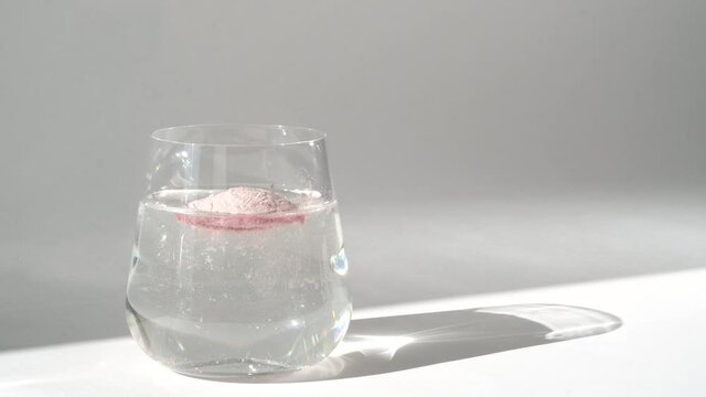 Adding collagen powder in glass of water for skin care. Super food additives.