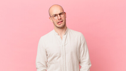 bald man feeling puzzled and confused, with a dumb, stunned expression looking at something...