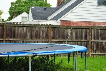 Dangerous live downed power line draped across fence and trampoline