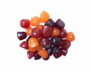 Close-up texture of red, orange and purple multivitamin gummies on white background. Healthy lifestyle concept.