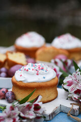 Easter. Spring. Easter cake with colored eggs, flowers on white wooden boards on a blue table. Background image, copy space, vertical