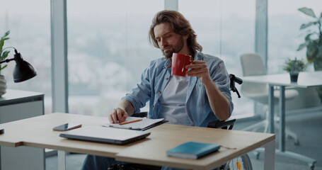 Disabled invalid young male designer working in corporate office, developing creative ideas and...