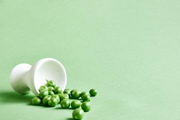 Minimal food creative concept. Fresh green peas on light green pastel background.