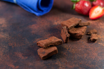 Chocolate pieces on a dark background. Close-up. Space for text