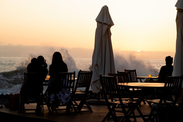 Fototapeta na wymiar happy people in silhouette enjoy luxury sunset on beach restaurant during vacations, Madeira island, Portugal 