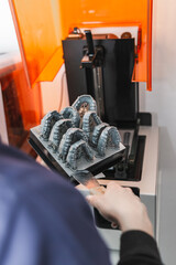 Dental technician removing jaw models from a 3d printer in the laboratory. Model for dental prostheses © Juan