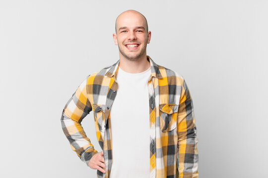 bald man smiling happily with a hand on hip and confident, positive, proud and friendly attitude