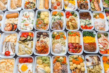 Airplane food presentation with variety of in flight meals.  Flight catering.  Food on airplanes. Salad bar buffet  display in restaurant.  Meat cuts. Hot appetizers. Close-up, a lot of food.
