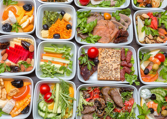 Airplane food presentation with variety of in flight meals.  Flight catering.  Food on airplanes. Salad bar buffet  display in restaurant.  Meat cuts. Hot appetizers. Close-up, a lot of food.
