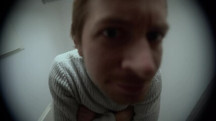 An angry man knocks on the door. View through the peephole