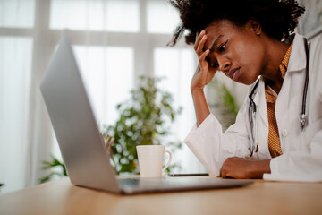 Stress and work concept - stressed or tired mature female doctor sitting in modern office.