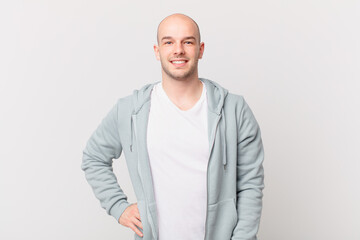 bald man smiling happily with a hand on hip and confident, positive, proud and friendly attitude