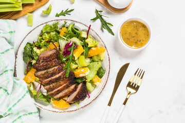 Salad with baked duck, green salad mix and oranges.