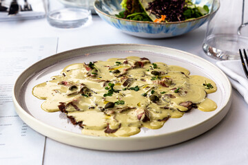 The traditional Italian dish vitello tonato is on the plate.
