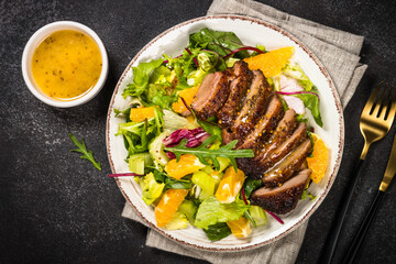 Salad with baked duck, green salad mix and oranges.