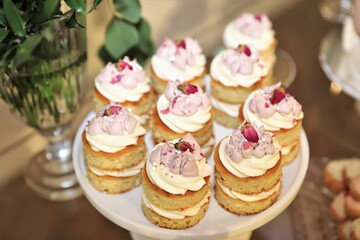 close up of small desserts with rose petals on top, the plates and table decorated for wedding ceremony