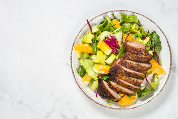 Salad with baked duck, green salad mix and oranges.