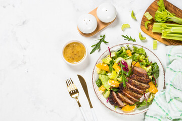 Salad with baked duck, green salad mix and oranges.