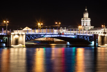 Fototapeta na wymiar Laying bridges in St. Petersburg. Night city of Russia. Neva River. Reflection of colored lights in the water. Long-term exposure.