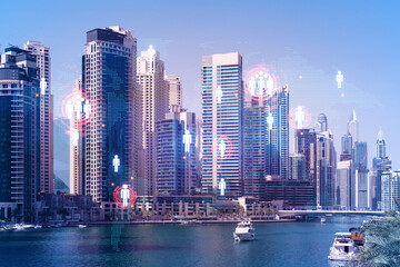 Fototapeta na wymiar Skyscrapers of Dubai business downtown. International hub of trading and financial services. Social network icons hologram, concept of human resources. Double exposure. Dubai Canal waterfront.