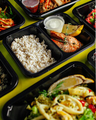 Healthy lunch at the workplace. Pick up food in black containers with cutlery