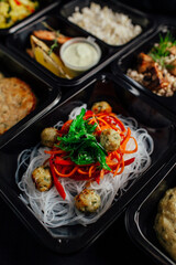 Healthy lunch at the workplace. Pick up food in black containers with cutlery