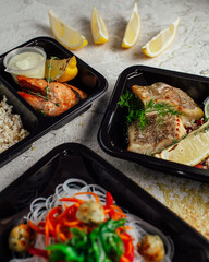 Healthy lunch at the workplace. Pick up food in black containers with cutlery